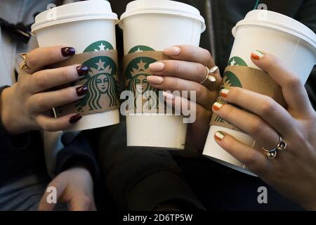 DUBLIN, IRLAND - 30. Mai 2017: Nahaufnahme von drei wunderschön gepflegten weiblichen Händen mit Ringen, die verschiedene Formen von Starbucks Kaffeetassen auf t halten Stockfoto