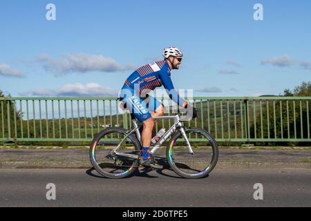 Männlicher Radfahrer, der Planet X Karbonfaser-Leichtbau-Sport-Rennrad auf Landstraße über Autobahnbrücke im ländlichen Lancashire, Großbritannien, fährt Stockfoto