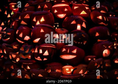 Hintergrund von geschnitzten und beleuchteten Halloween Kürbisse leuchten im Dunkeln. Stockfoto