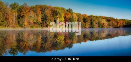 Rose Lake am nebligen Morgen. Nebel über Wasser mit bunten Bäumen in Hocking Hills ohio am klaren Herbstmorgen. Herbsttöne von rot, gelb und orange i Stockfoto