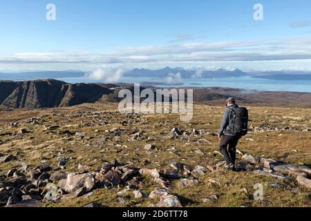 Walker auf Sgurr a Chaorachain mit Blick über die Bealach na Ba the in Richtung Isle of Skye, Applecross, Schottland, Großbritannien Stockfoto