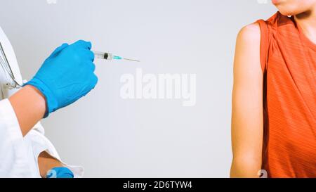 Arzt impfen Kind für Coronavirus in der Klinik. Spritze mit Handschuhen geschützte Hände. Stockfoto