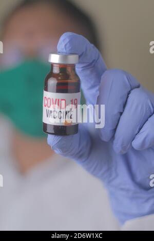 Arzt, Krankenschwester, Wissenschaftler, Forscher Hand in blauen Handschuhen hält Grippe, Masern, Coronavirus, covid-19-Impfstoff-Krankheit Vorbereitung für menschliche klinische Tria Stockfoto