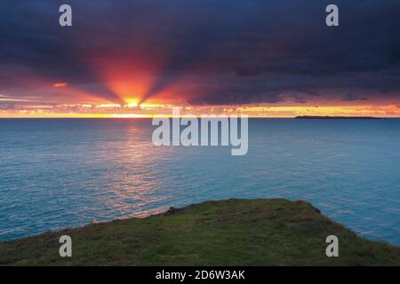 Erstaunlicher orangefarbener Sonnenuntergang, St. Anns Head mit Skokholm Island, Pembrokeshire, Wales Stockfoto