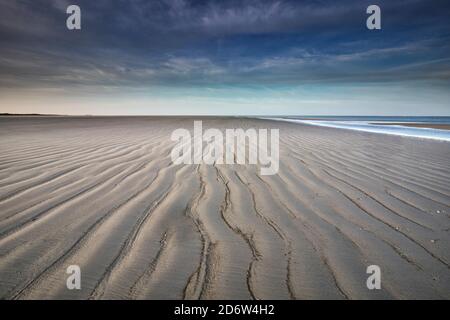 Wellen Sie Sand Texturen am Strand bei Ebbe Stockfoto