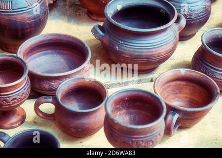 Töpferei im alten Stil handgefertigt. Draufsicht auf Tontöpfe, Vasen, Tassen und Krüge. Meisterwerke in Töpferwerkstatt. Stockfoto