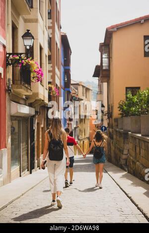 Eine Gruppe von Freunden, die durch das pintoreske Dorf Bermeo in Vizcaya, Spanien, wandern Stockfoto