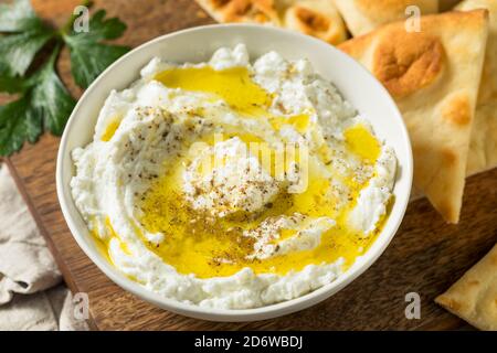 Hausgemachter Joghurt Labneh Käse Dip mit Olivenöl und Pita Stockfoto