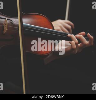 Nahaufnahme der Geige mit Bogen in den Händen - spielend Violin-Konzept Stockfoto