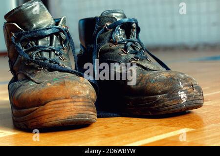 Alte abgenutzte Arbeitsschuhe. Schuhe, die repariert oder ersetzt werden müssen Stockfoto