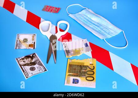 Schneiden Sie Geld Dollar und Euro auf einem blauen Hintergrund. Das Konzept der Probleme im globalen Finanzsystem aufgrund der wirtschaftlichen unter der Quarantäne der c Stockfoto