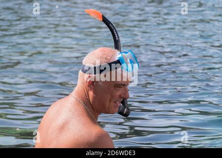 PON, ITALIEN - 23. Sep 2020: Pensionierter Mann schwimmt mit Schnorchel im kristallklaren Wasser Stockfoto