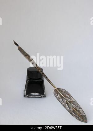 Alte Tintenstift mit Metall filigreed und Tintenflasche isoliert auf weißem Hintergrund. Vintage Kalligraphie Stift und Flasche Tinte. Stockfoto