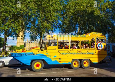 Gelbes Sightseeing-Fahrzeug voller aufgeregter Touristen, die weiter fahren Parliament Square vor dem Westminster Palace auf schön sonnig Sommertag, London Großbritannien Stockfoto