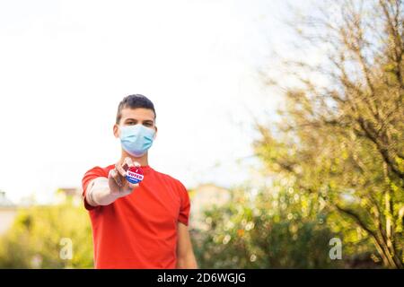 Mann mit Gesichtsmaske, die zeigt, dass ich heute an der Wahlurne abstimme. Stockfoto