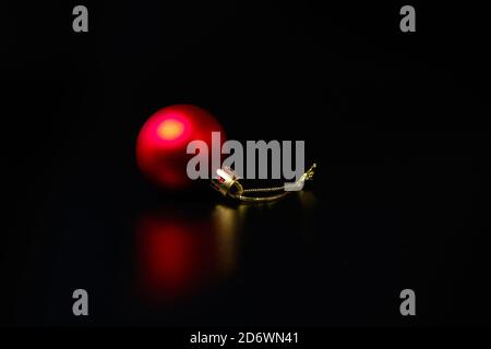 Roter Neujahrsbaum oder Weihnachtsbaum Dekoration. Rote Kugel auf schwarz Stockfoto