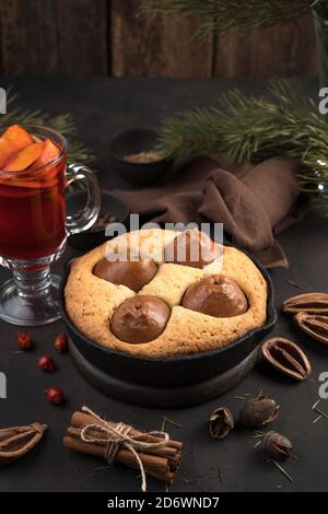 Gemütliche weihnachtliche Komposition in braunen Farben. Hausgemachter Kuchen und Glühwein, Seitenansicht, vertikale Ausrichtung. Stockfoto