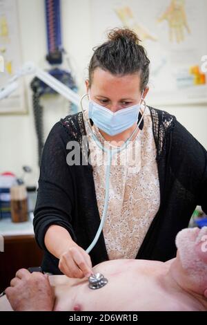 Mann in Absprache mit einem Hausarzt mit einer OP-Maske, Frankreich, juni 2020. Stockfoto