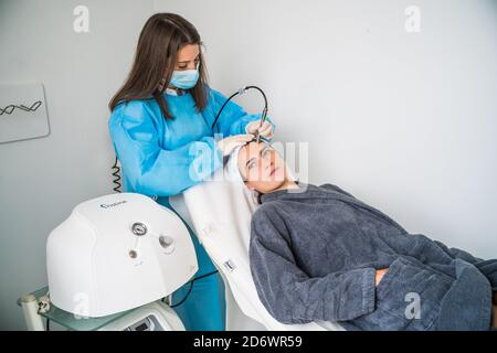 Mikrodermabrasion des Gesichts, eine Technik, die abgestorbene Zellen und Verunreinigungen aus der Epidermis beseitigt, Peeling der Oberflächenschicht der Haut, C Stockfoto