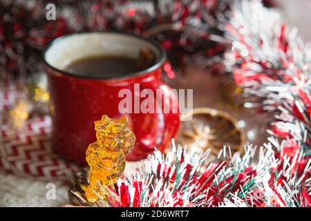 Zwei Lutscher auf Stick in Form von Symbol Neujahr 2021 - Stier auf dem Hintergrund Weihnachtsdekor mit einer roten Tasse Tee. Girlanden, Zimt und getrocknet o Stockfoto