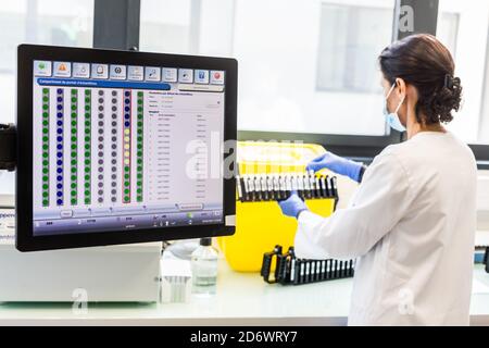 Laden der Reagenzien von COVID-19 Screening-PCR-Testproben in die automatische Maschine, Krankenhaus-Analyselabor Limoges, Frankreich. Stockfoto