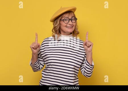 Aufgeregt reifen Frau aussehen fasziniert und amüsiert, zeigt die Finger nach oben. Stockfoto