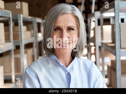 Glückliche reife weibliche Manager in Lieferung Versand Lager, Kopfschuss Porträt. Stockfoto