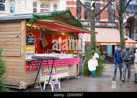 16. Dezember 2019, Gent, Belgien. Menschen und beleuchteten Weihnachtsmarkt Pavillon mit Lebensmitteln. Stockfoto