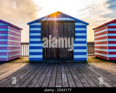 Strandhütte mit Sonnenuntergang von hinten am Hastings Pier Stockfoto