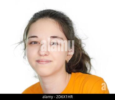 Porträt eines jungen Mädchens in einem orangefarbenen T-Shirt auf weißem Hintergrund. Stockfoto