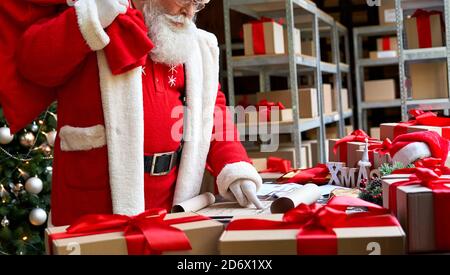 Weihnachtsmann mit Sack Tasche mit Geschenken Geschenke Lesen Wunschliste. Stockfoto