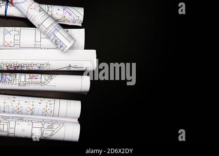 Architekturprojekt, Zeichnungen auf dunklem Hintergrund. Rollen von Projektzeichnungen. Stockfoto