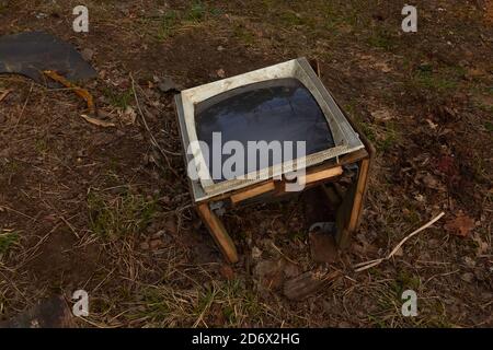 Alter kaputter Fernseher auf dem Boden mit schwarzem Bildschirm. Stockfoto