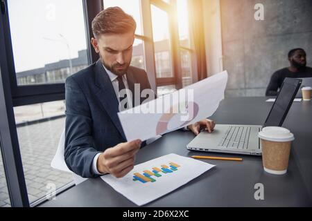 Geschäftsmann arbeitet im Büro mit einer Statistik. Konzept von Erfolg und Startup. Isoliert auf weißem Hintergrund Stockfoto