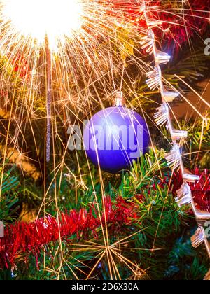 Weihnachtsdekoration auf einem Weihnachtsbaum mit viel schöner Funkelt von einem Wunderkerzen Stockfoto