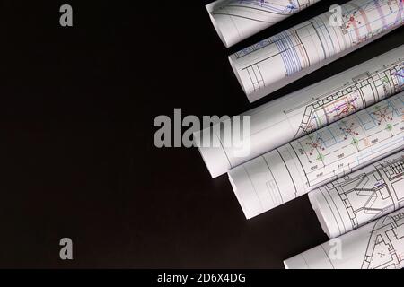 Architekturprojekt, Zeichnungen auf dunklem Hintergrund. Rollen von Projektzeichnungen. Stockfoto