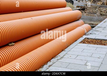 Kunststoff-PVC-Rohre in Reihen auf der Baustelle auf gestapelt Wiederaufbau des städtischen Wassersystems Stockfoto