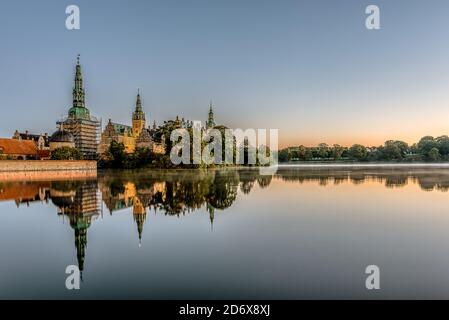 Der spiegelglänzende See von Frederiksborg mit Spiegelungen des erleuchteten Schlosses bei Sonnenaufgang, Hillerod, Dänemark, 17. Oktober 2020 Stockfoto