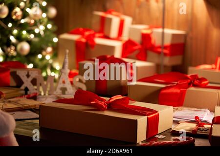 Weihnachts-Geschenkbox auf dekorierten Weihnachtstisch in gemütlicher Weihnachtswerkstatt. Stockfoto