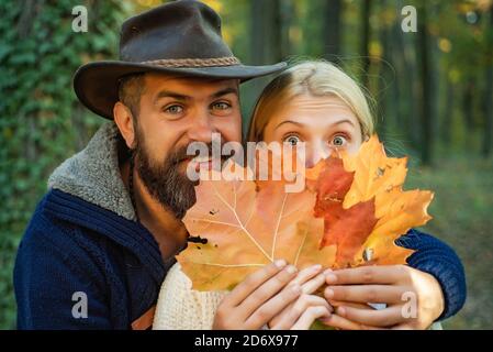 Herbst paar auf Herbst Natur Hintergrund. Sorglose junge Frau mit hübscher bärtiger Mann im trendigen Vintage Pullover oder Pullover und Cowboy Hut. Stockfoto