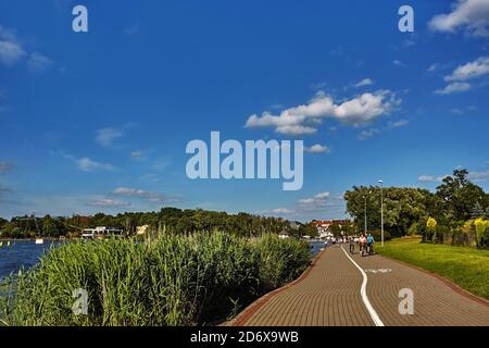 Touristen, die im Sommer in Ostróda, Polen, eine Radtour auf dem Hafen des Drwęca-Sees Unternehmen Stockfoto