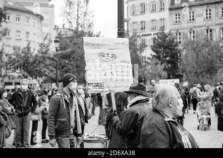 Straßburg, Frankreich - 19. Oktober 2020: Mann mit Plakat an Ort und Stelle Kleber zu Ehren des Geschichtslehrers Samuel Paty zu zahlen, enthauptet am 16. Oktober, nachdem er Karikaturen des Propheten Muhammad in der Klasse gezeigt Stockfoto