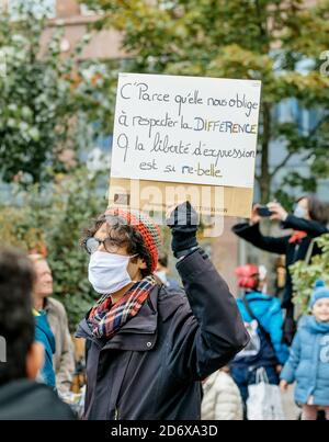 Straßburg, Frankreich - 19. Oktober 2020: Junger Mann mit OP-Maske und Plakat zollt dem Geschichtslehrer Samuel Paty Tribut, der am 16. Oktober enthauptet wurde, nachdem er Karikaturen des Propheten Muhammad im Unterricht gezeigt hatte Stockfoto