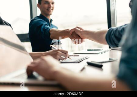 Nahaufnahme. Junge Geschäftsleute, die einen neuen Vertrag eingehen. Stockfoto