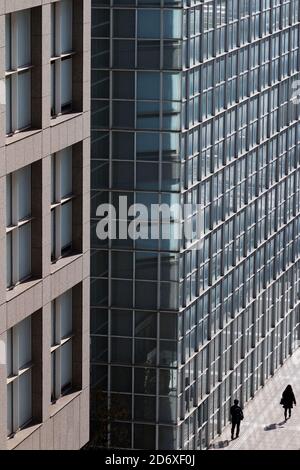 Silhouetten eines Mannes und einer Frau, die durch das Wolkenkratzerviertel von Shinjuku, Tokio, Japan, Stockfoto