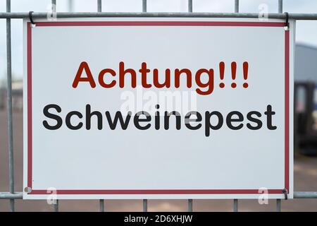 Schild mit der Aufschrift 'Achtung Schweinepest' Auf einem Zaun zu einem Bauernhof in Deutschland Stockfoto