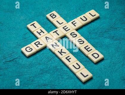 Dankbare, dankbare, gesegnete spirituelle Worte - Kreuzworträtsel in Elfenbeinbuchstaben gegen handgeschöpftes Rindenpapier, Thanksgiving-Konzept oder Grußkarte Stockfoto