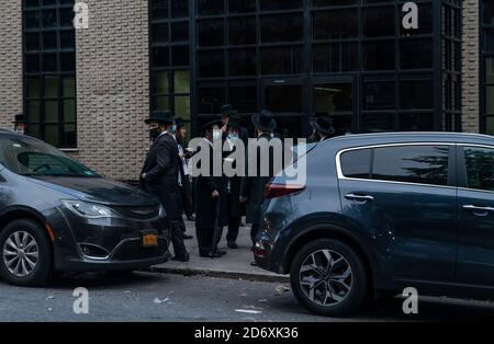 New York, Usa. Oktober 2020. Menschen versammeln sich außerhalb der Kongregation Yetev Lev D'Satmar, wo Staatsbeamte stoppen geplante 10,000-Personen-Hochzeit in Brooklyn, New York am 19. Oktober 2020. Der Staat New York erließ einen Befehl, der die Massenversammlung, die gegen die Beschränkungen des Coronavirus verstoßen würde, ausschloss, der von Dr. Howard Zucker, dem Beauftragten des Gesundheitsministeriums, unterzeichnet wurde. (Foto von Lev Radin/Sipa USA) Quelle: SIPA USA/Alamy Live News Stockfoto