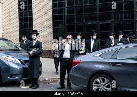 New York, Usa. Oktober 2020. Menschen versammeln sich außerhalb der Kongregation Yetev Lev D'Satmar, wo Staatsbeamte stoppen geplante 10,000-Personen-Hochzeit in Brooklyn, New York am 19. Oktober 2020. Der Staat New York erließ einen Befehl, der die Massenversammlung, die gegen die Beschränkungen des Coronavirus verstoßen würde, ausschloss, der von Dr. Howard Zucker, dem Beauftragten des Gesundheitsministeriums, unterzeichnet wurde. (Foto von Lev Radin/Sipa USA) Quelle: SIPA USA/Alamy Live News Stockfoto