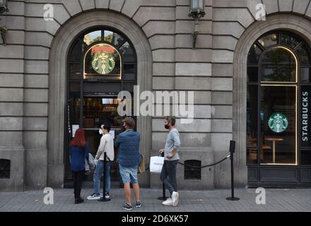 Barcelona, Spanien. Oktober 2020. Menschen mit Gesichtsmast warten vor dem Starbucks Coffee Store auf der Las Ramblas Street.die katalanische Regierung hat Restaurants und Bars für zwei Wochen geschlossen, um die Mobilität und soziale Interaktion in der nordspanischen Region zu verringern, um die Eskalation der COVID-19 Fälle anzugehen. Kredit: SOPA Images Limited/Alamy Live Nachrichten Stockfoto